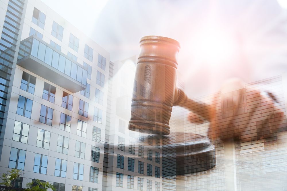 Double exposure of judge with gavel and building