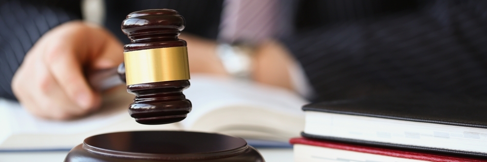 closeup with selected focus of an attorney holding a gavel at a desk