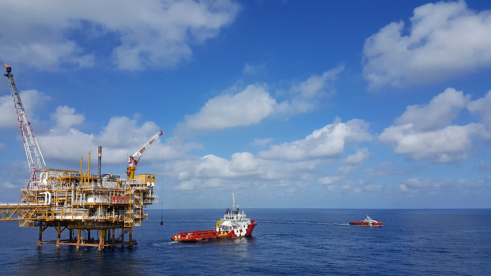 Supply boat transfer offshore worker and cargo by personnel basket from oil platform