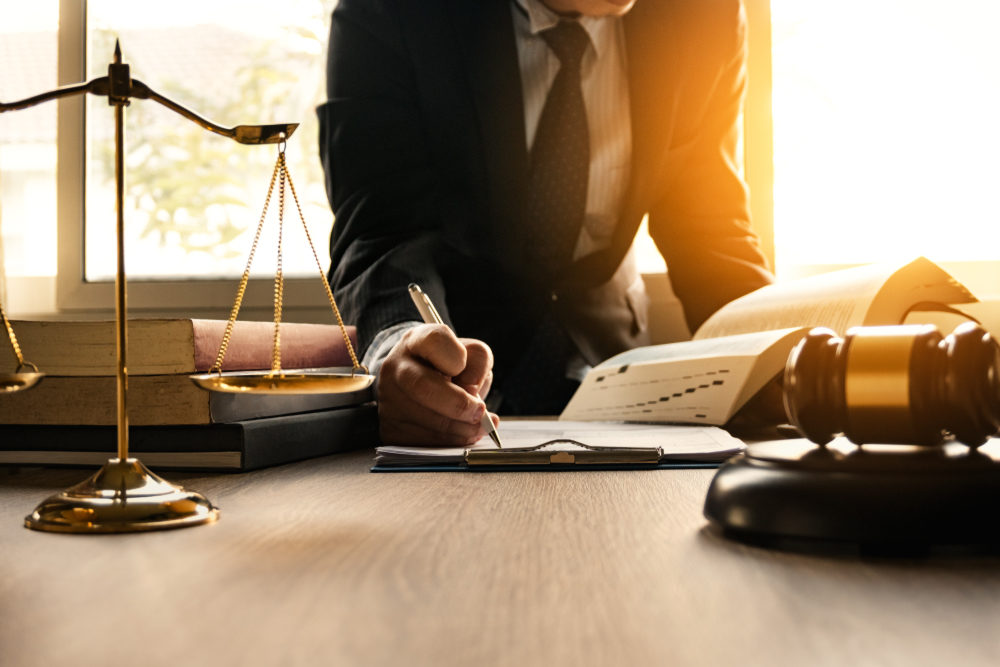 Male lawyer working with contract papers and wooden gavel on table