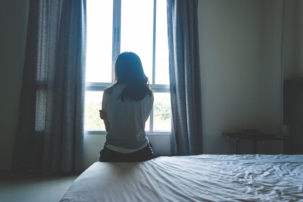 Woman sitting along on bed