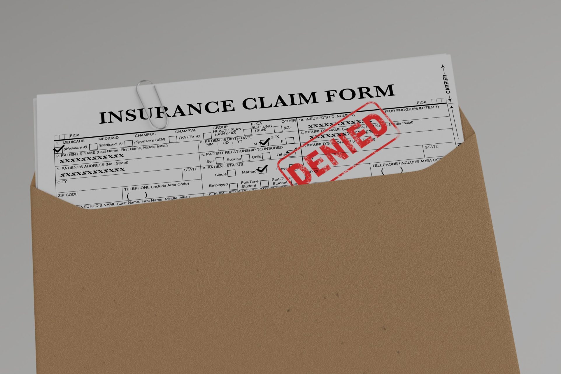 Insurance claim form document in brown envelope with denied stamp