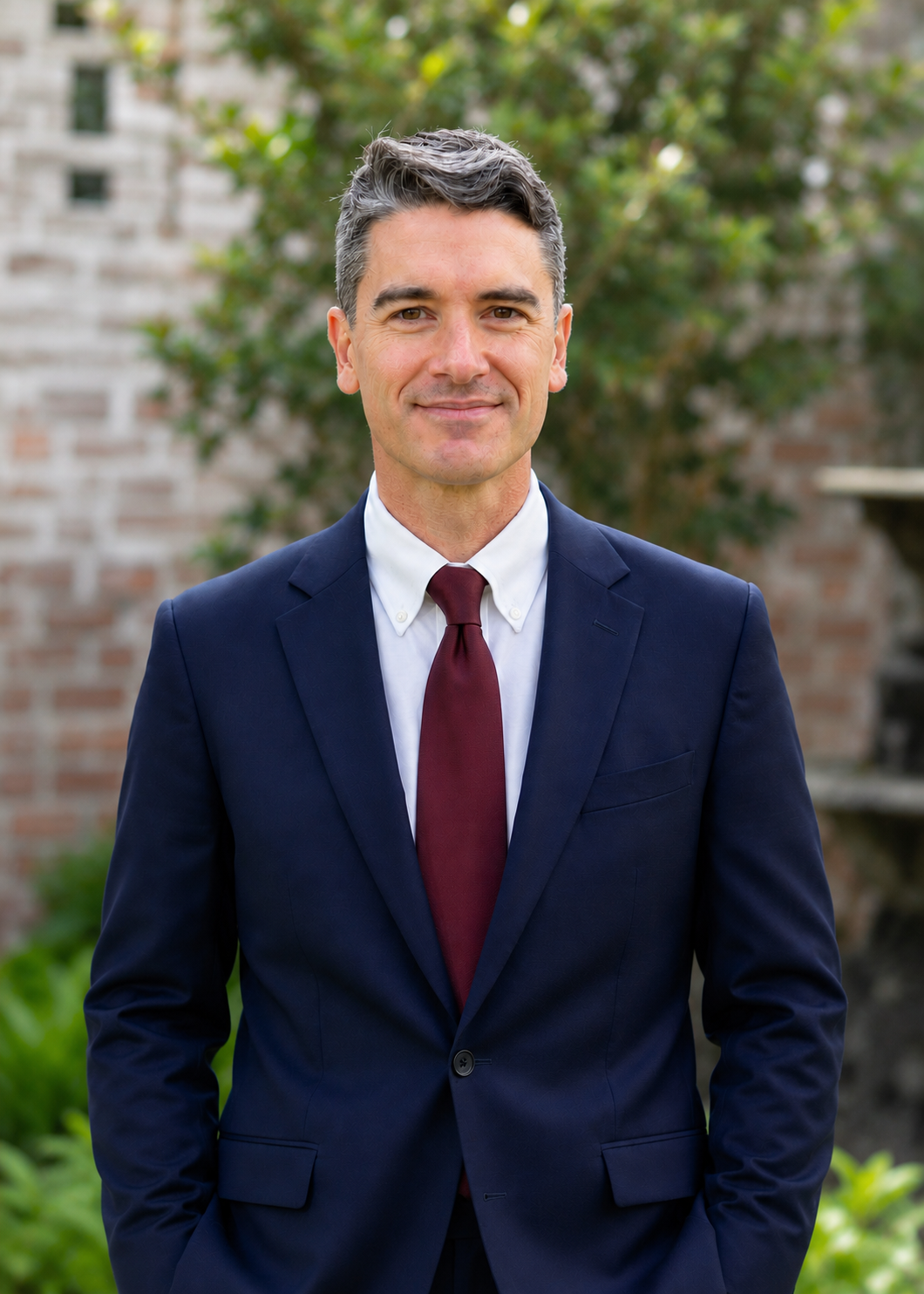 Jed Cain headshot for 2026 in a suit with trees in background